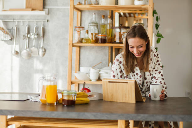 istock Smiling young woman using digital tablet in the morning 1145089239