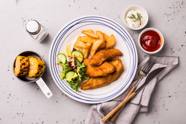 istock Lunch or dinner - chicken strips, french fries, corn and dips 1145091903