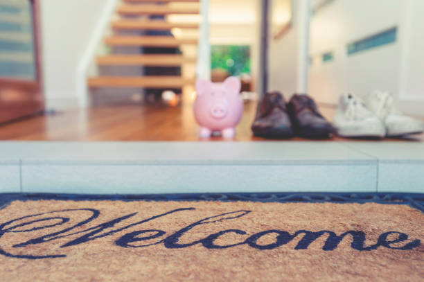 istock Saving for a new home concept. Piggy bank standing at front door 1145091921