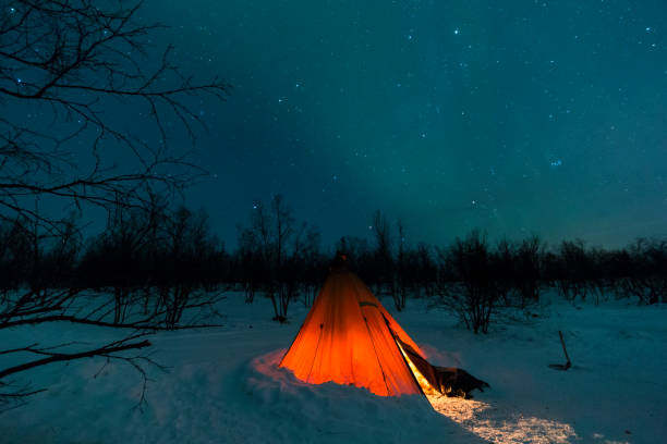 istock Epic orange lit tipi tent with northern lights and star sky 1145094430