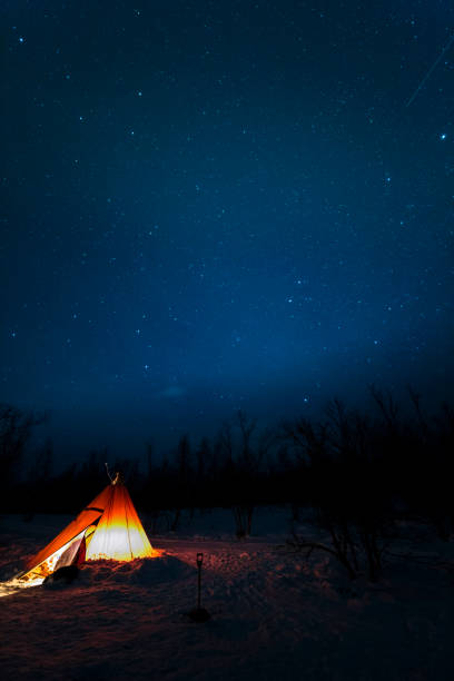 istock Epic orange lit tipi tent with northern lights and star sky 1145094527