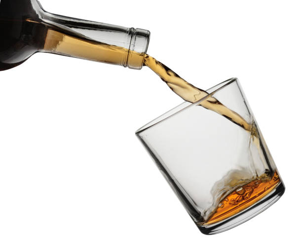 istock Brandy from a bottle flows in a glass. Isolated on a white background 1145094553
