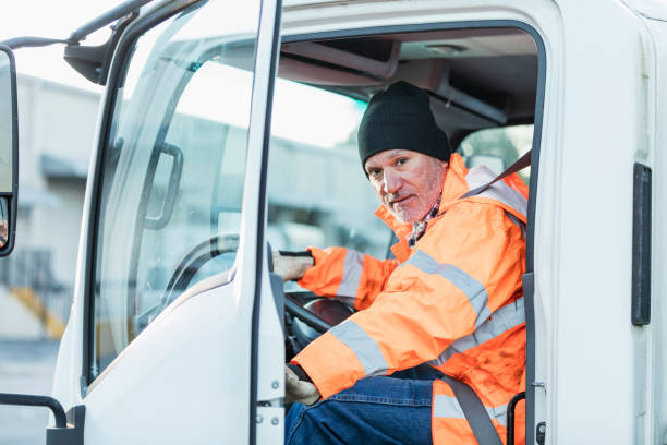 istock Hispanic truck driver sitting in vehicle, at warehouse 1145096059