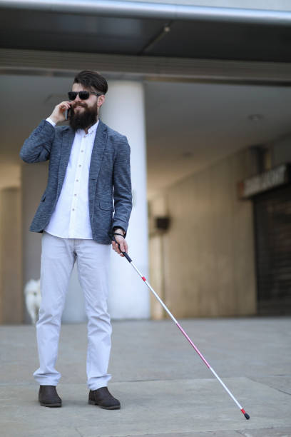 istock Blind and bearded man with a walking stick on the street 1145097931