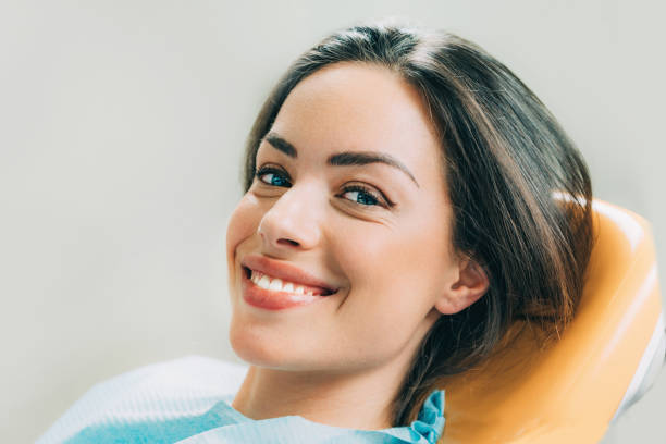 hermosa paciente mujer sentada en silla de dentista - human mouth human teeth indoors young women fotografías e imágenes de stock