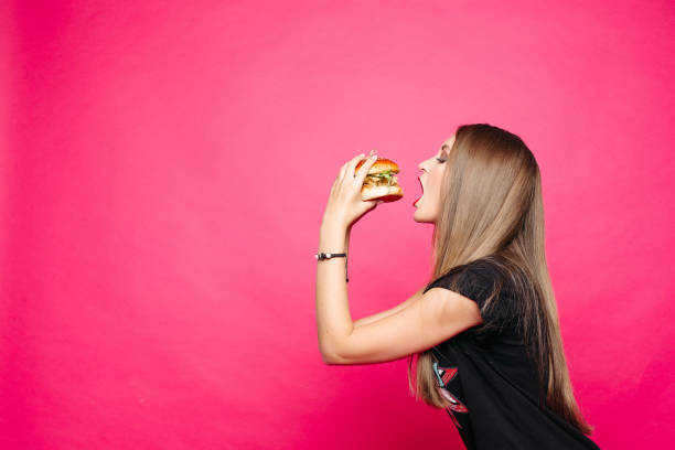 istock Hungry girl biting burger.burger with chicken and salad 1145100297