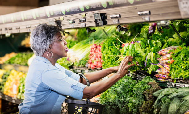 anziana donna afroamericana che fa shopping al supermercato - supermarket groceries shopping healthy lifestyle foto e immagini stock