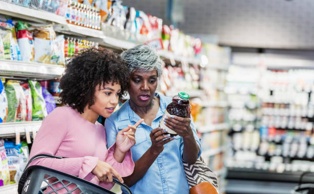 deux femmes afro-américaines dans le supermarché - information nutritionnelle photos et images de collection