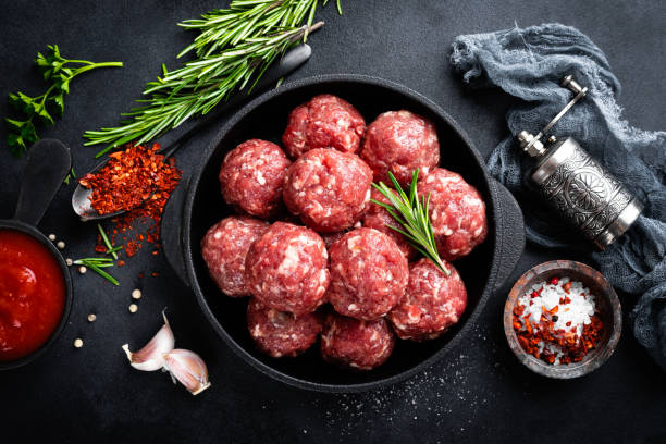 istock Fresh raw beef meatballs with spices and tomato sauce 1145101987
