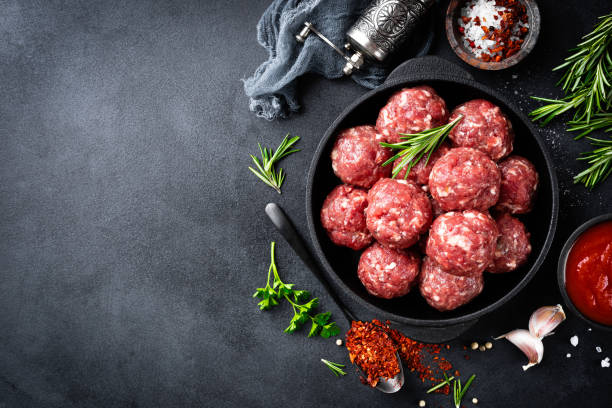 istock Fresh raw beef meatballs with spices and tomato sauce 1145103179