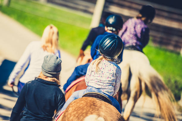 istock Children riding horses 1145104178