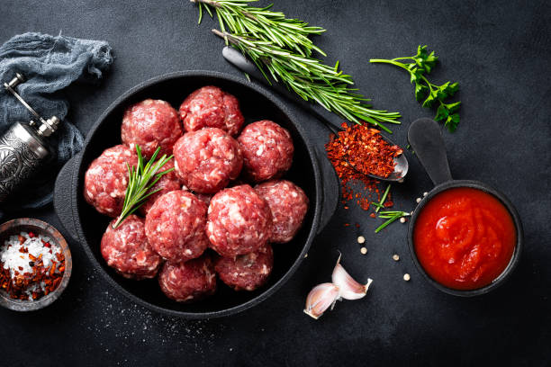 istock Fresh raw beef meatballs with spices and tomato sauce 1145105279