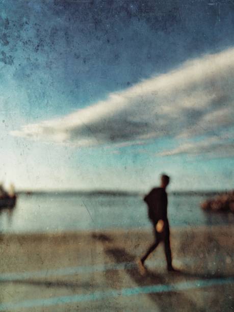 istock Defocused textured view of a man walking on the coastline 1145105340