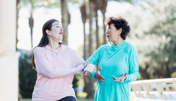 istock Two Hispanic women walking in park 1145106262