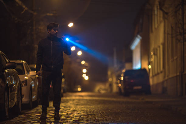 istock The man with a flashlight stand on the road. Evening night time 1145106727