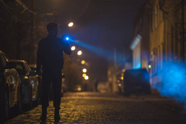 istock The man with a flashlight stand on the road. Evening night time 1145106754