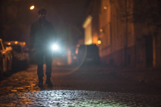 istock The man with a flashlight stand on the road. Evening night time 1145106798