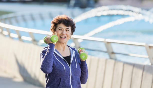 istock Senior Hispanic woman exercising with hand weights 1145106804