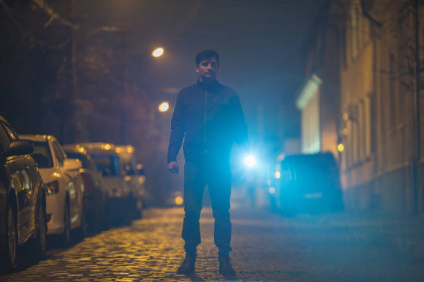 istock The man with a flashlight stand on the street. Evening night time 1145106827