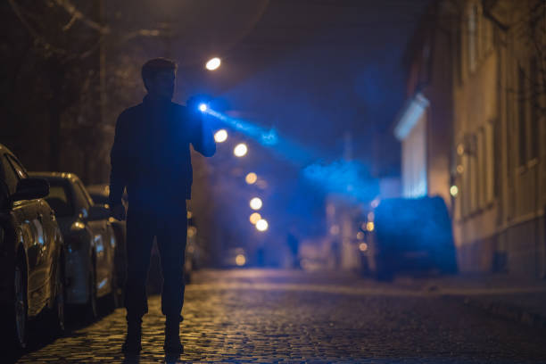 istock The man with a flashlight stand on the road. Evening night time 1145106831