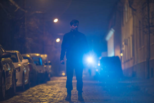 istock The man with a flashlight stand on the street. Evening night time 1145106908