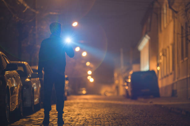 istock The man with a flashlight stand on the street. Evening night time 1145106919