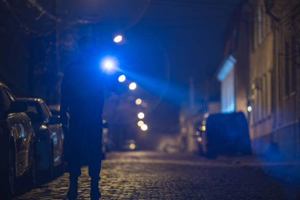 istock The man with a flashlight stand on the street. Evening night time 1145106922