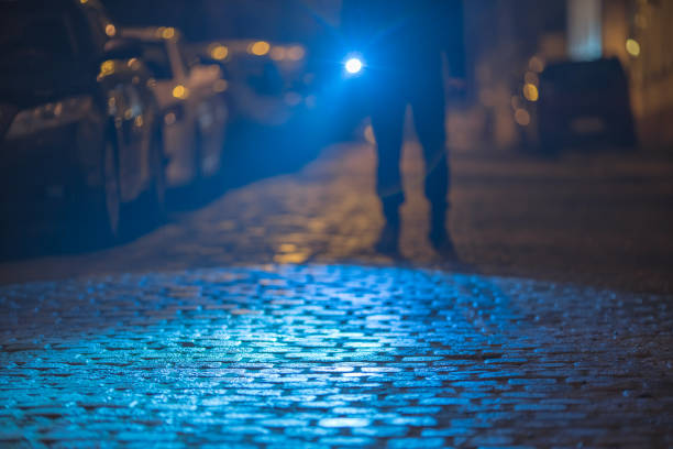 istock The man with a flashlight inspect the street. Evening night time 1145107158