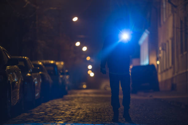istock The man with a flashlight stand on wet road. Evening night time 1145107439