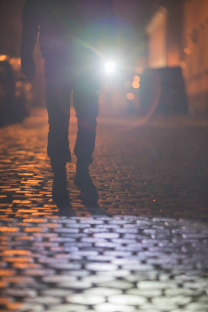 istock The man with a flashlight stand on the road. Evening night time 1145107451