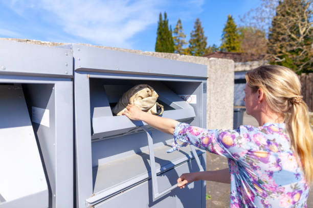istock Young woman puts a jacket in an old clothes container 1145107707