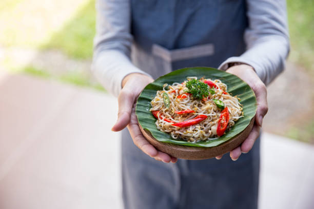 istock hand carrying indonesian food 1145112724