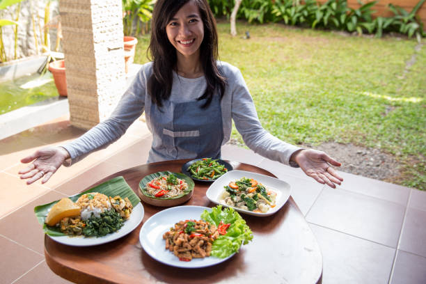 istock woman presenting various indonesian food 1145112812