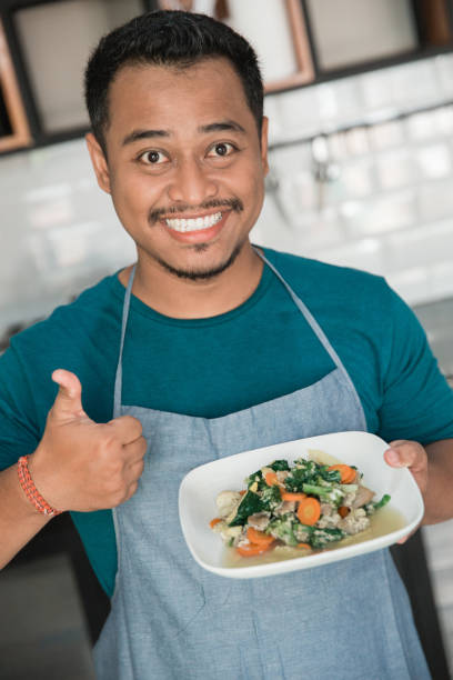 istock man with apron carrying food 1145115598