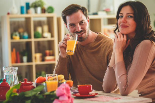 istock Couple drinking coffee and juice at home 1145121836