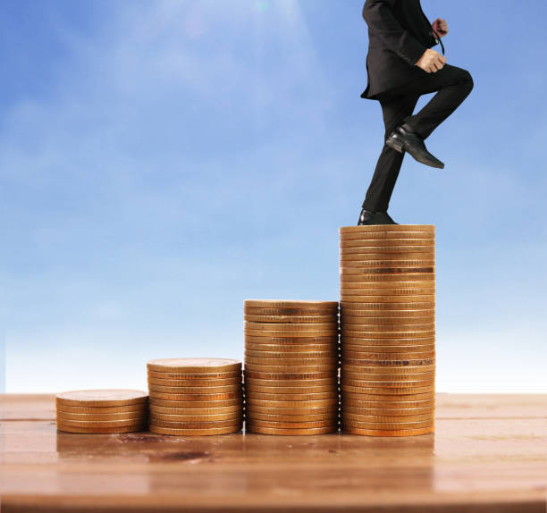 istock Businessman walk on stack of coins which grows success 1145128569