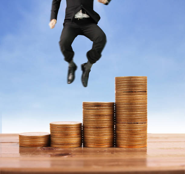 istock Businessman walk on stack of coins which grows success 1145128574