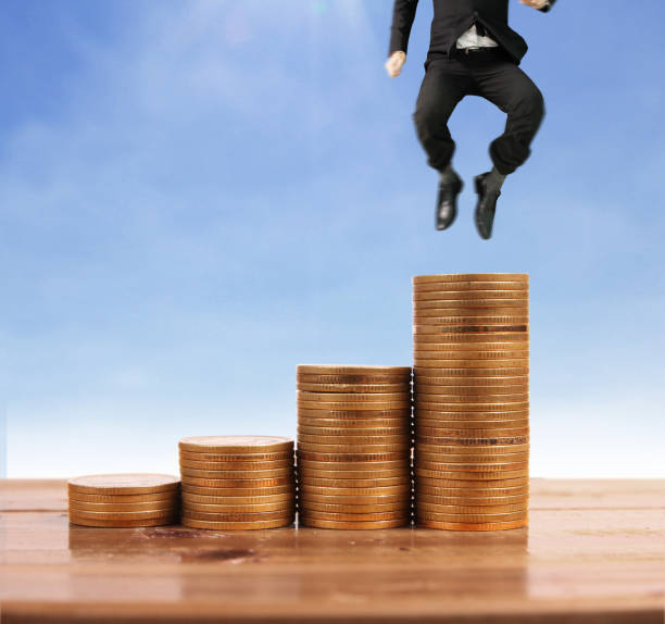 istock Businessman walk on stack of coins which grows success 1145128575