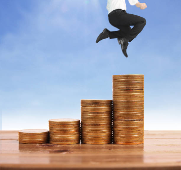 istock Businessman walk on stack of coins which grows success 1145128576