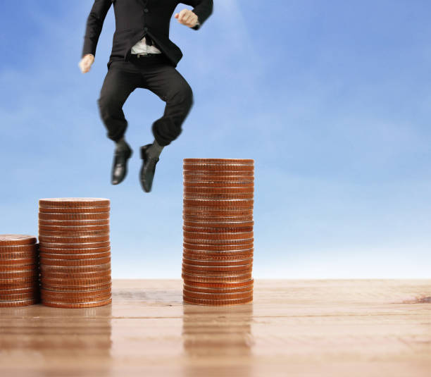 istock Businessman walk on stack of coins which grows success 1145128581