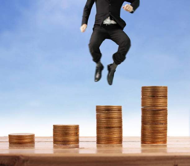 istock Businessman walk on stack of coins which grows success 1145128582