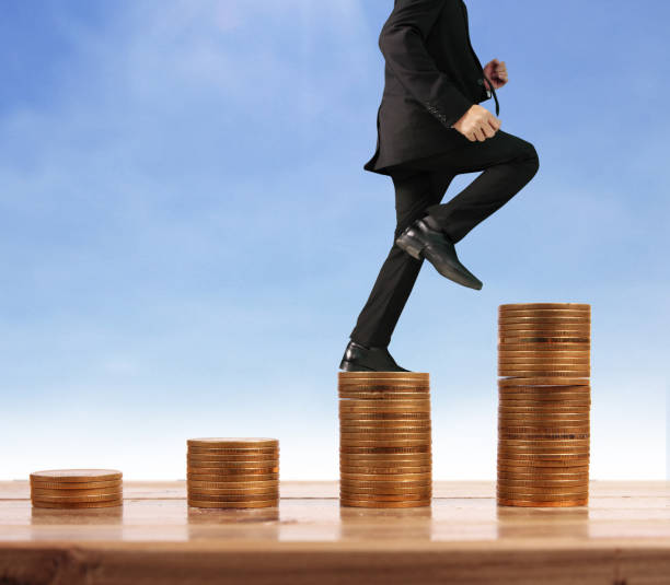 istock Businessman walk on stack of coins which grows success 1145128584