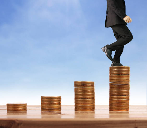 istock Businessman walk on stack of coins which grows success 1145128585