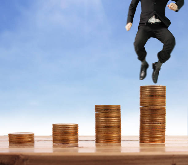 istock Businessman walk on stack of coins which grows success 1145128588