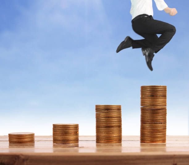 istock Businessman walk on stack of coins which grows success 1145128598