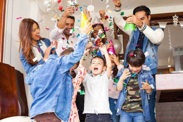 Latin family celebrating the birthday of the little one in the family. Everyone is happy throwing confetti in the air. Latin family celebrating the birthday of the little one in the family. Everyone is happy throwing confetti in the air. happy birthday cousin stock pictures, royalty-free photos & images