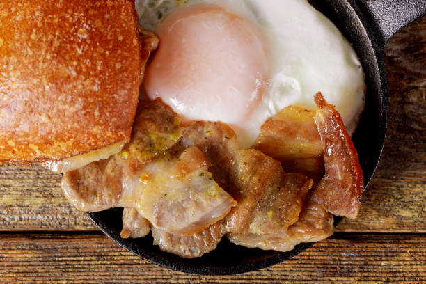 istock Breakfast on American fried eggs fried bacon wood background. view from above. 1145134316