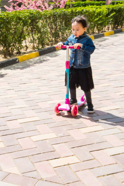istock a little girl playing skate scooter 1145136399