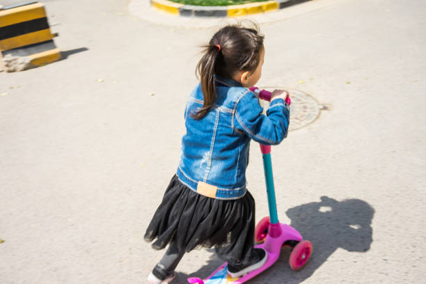istock a little girl playing skate scooter 1145136487