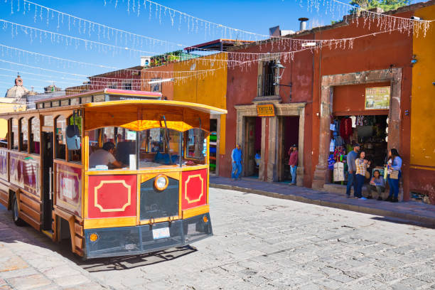 autobus turistico nel centro storico della città che va alle principali attrazioni turistiche di san miguel - mexico san miguel de allende wall road foto e immagini stock